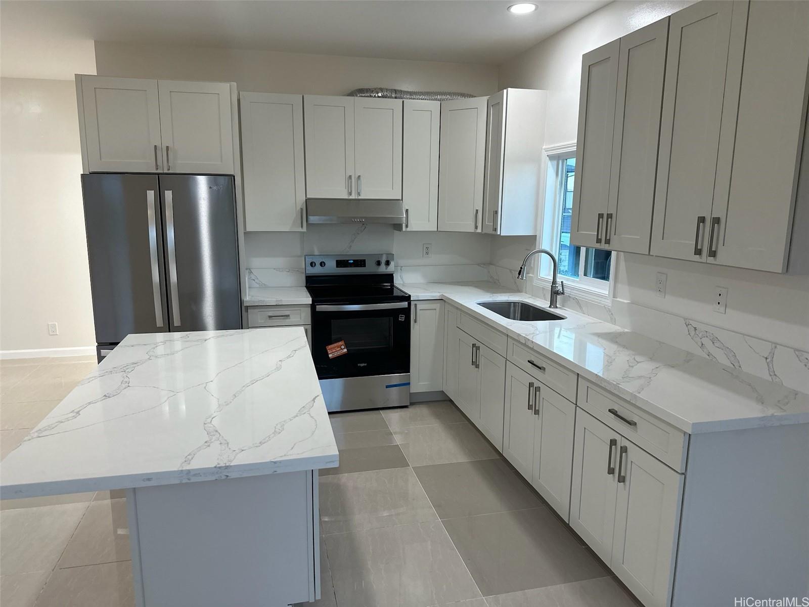 a large kitchen with stainless steel appliances granite countertop a sink stove and refrigerator