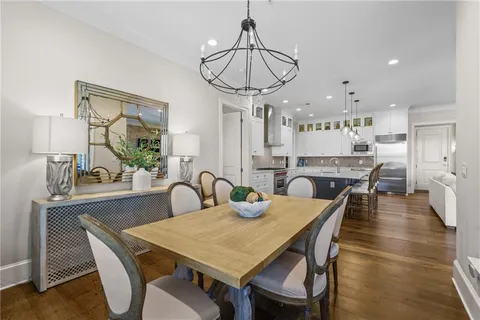 a dining room with furniture a chandelier and wooden floor
