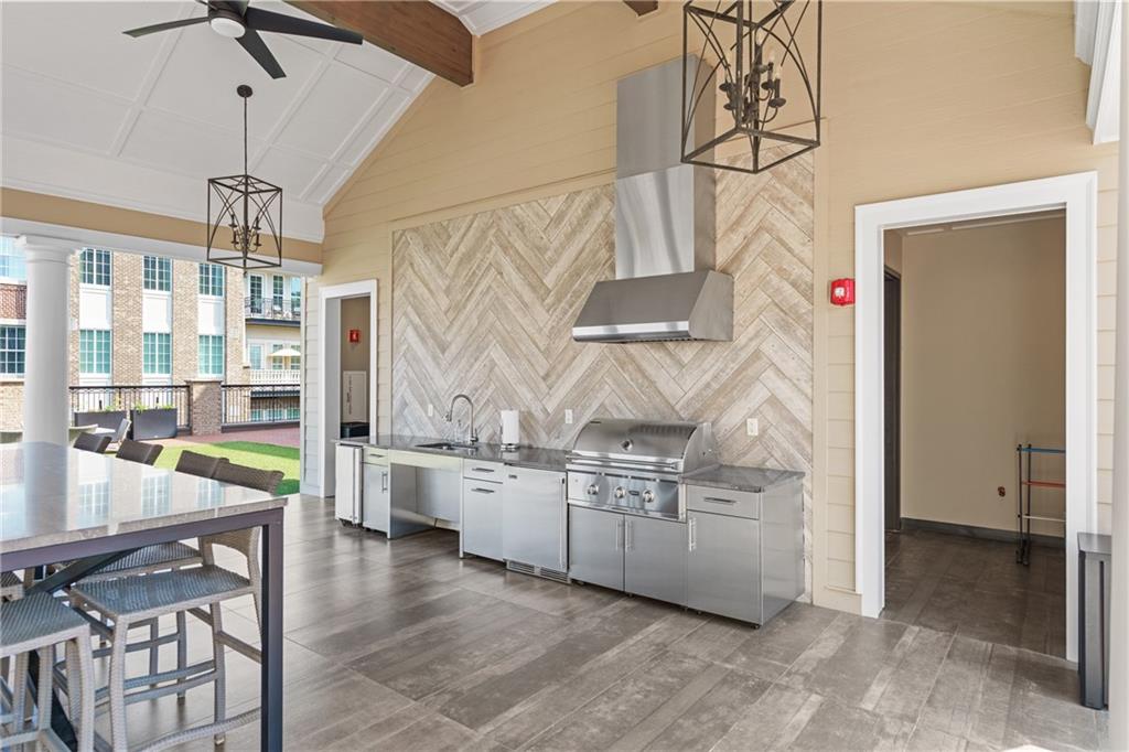 50 Canton Street, Unit 307 Alpharetta, GA 30009 - Photo 38 of 56 a kitchen with stainless steel appliances kitchen island granite countertop a table and chairs in it