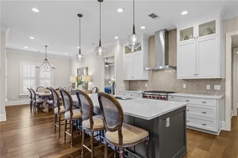 a large kitchen with kitchen island a island a stove a table and chairs in it