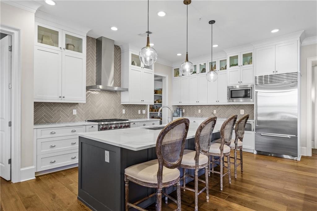 50 Canton Street, Unit 307 Alpharetta, GA 30009 - Photo 10 of 56 a large kitchen with kitchen island a large island a stove a table and chairs in it