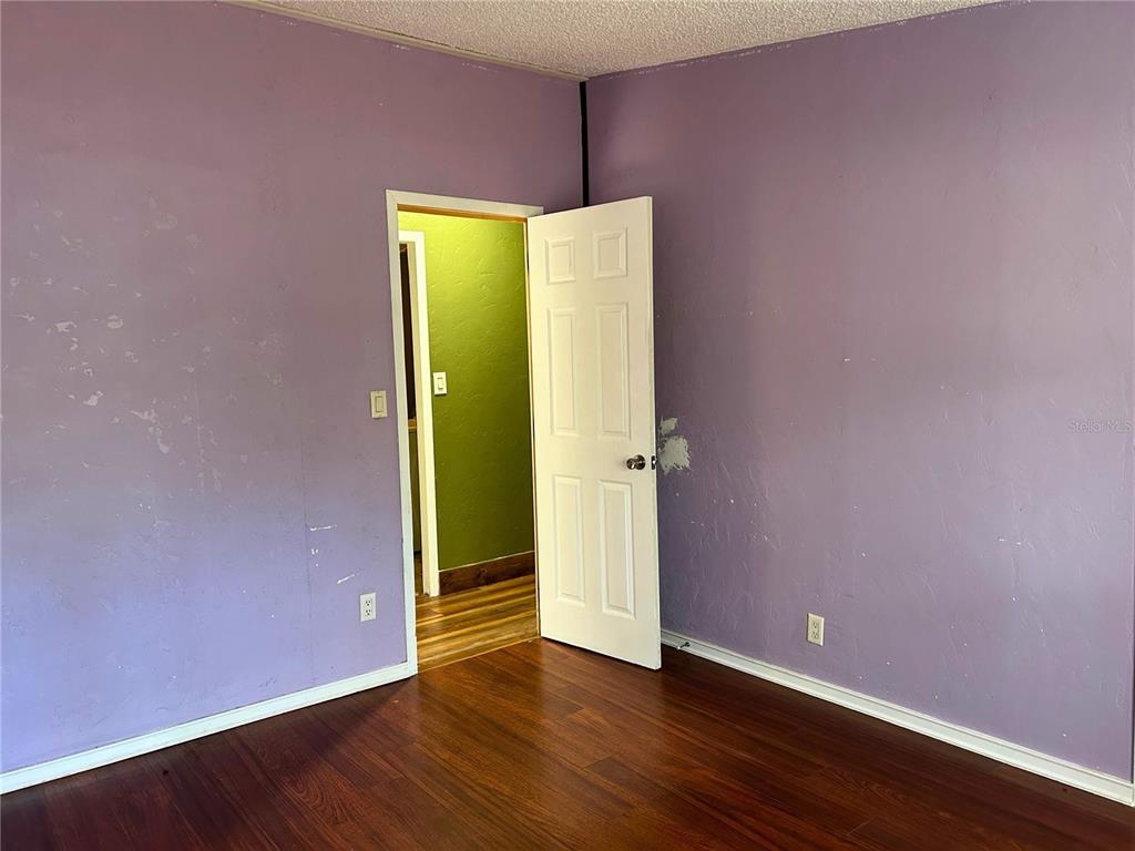 9867 Jerome Drive New Port Richey, FL 34654 - Photo 22 of 30 a view of an empty room with wooden floor and a wall