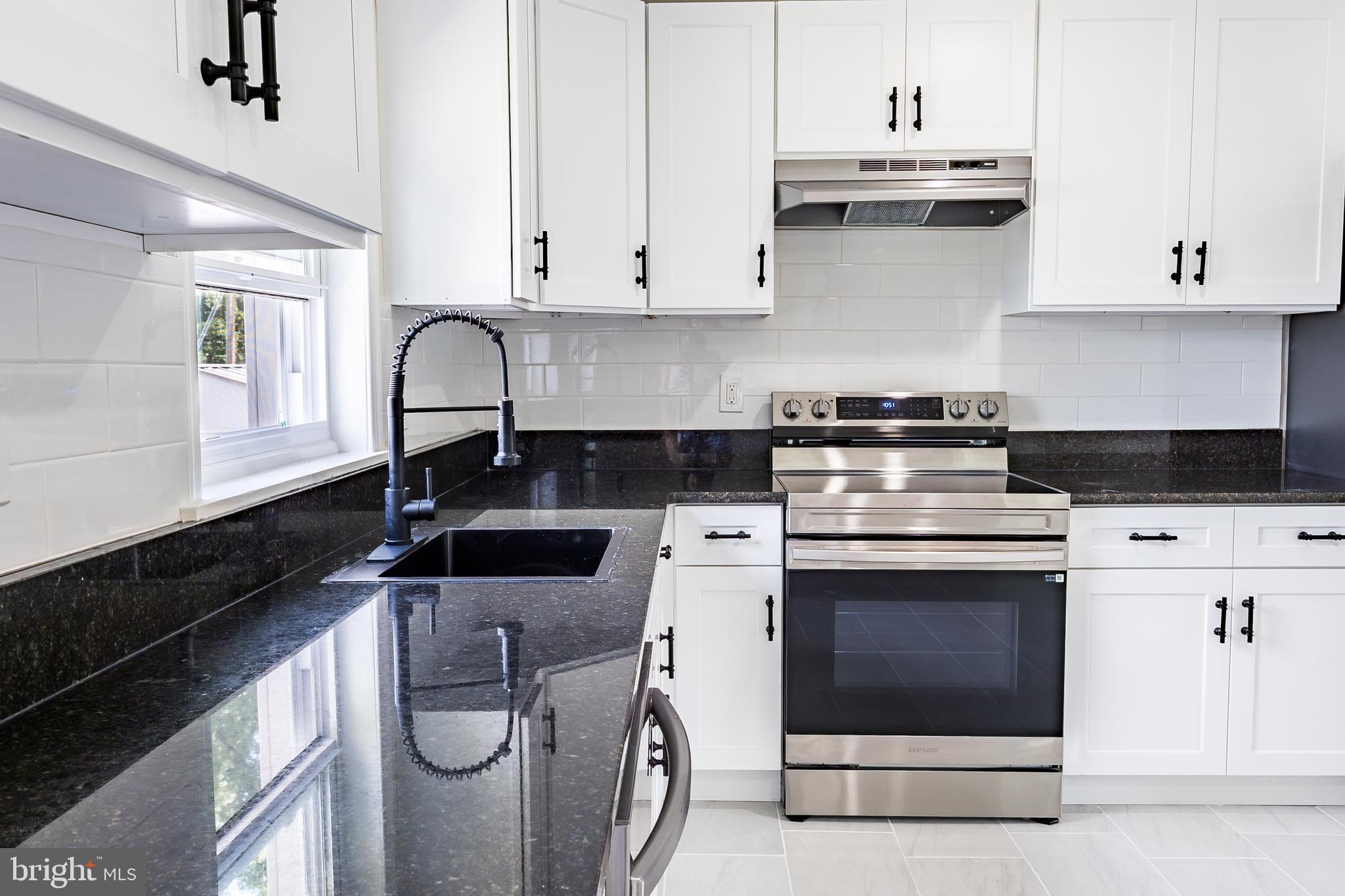 Elliot Avenue Bethlehem, PA 18018 - Photo 17 of 39 a kitchen with stainless steel appliances granite countertop a stove a sink and white cabinets