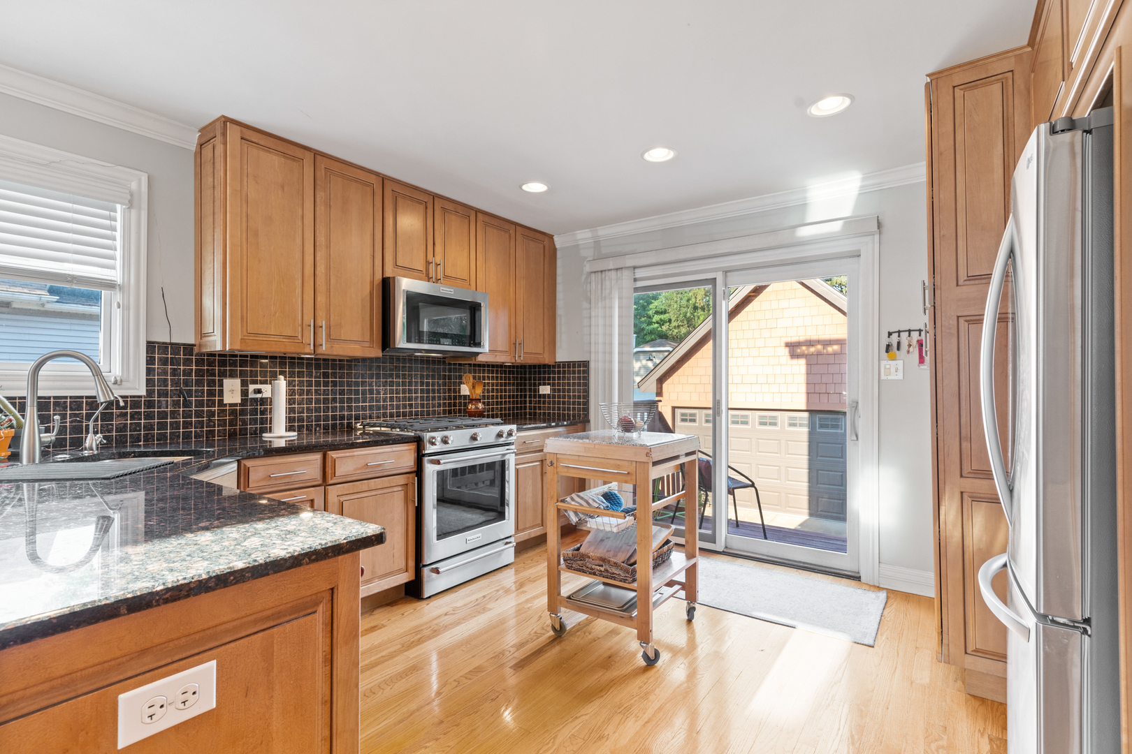 424 Willow Street Itasca, IL 60143 - Photo 11 of 47 a kitchen with stainless steel appliances granite countertop a refrigerator a sink a stove top oven and a dining table with wooden floor