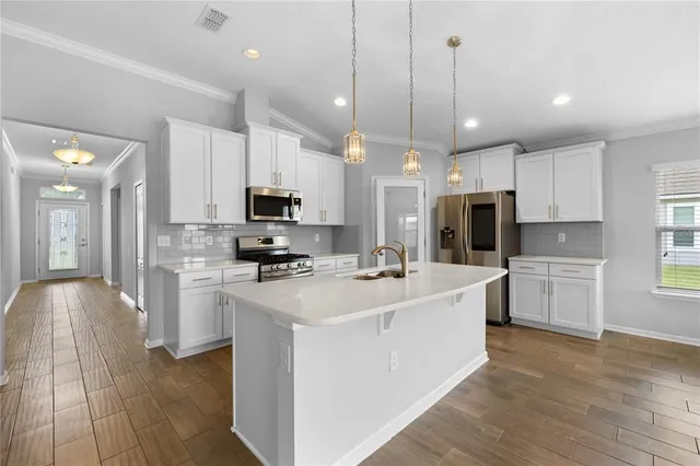 a large white kitchen with stainless steel appliances