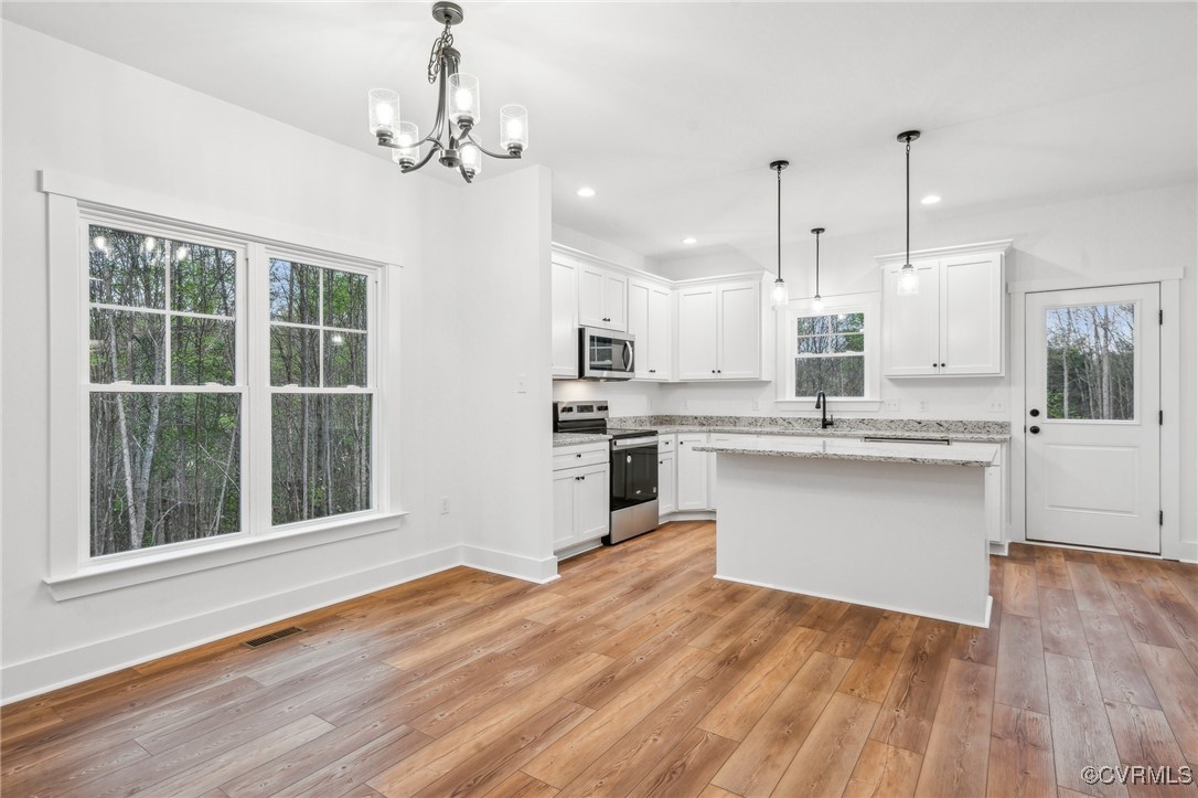 2467 Judes Ferry Road Powhatan, VA 23139 - Photo 13 of 36 a kitchen with stainless steel appliances granite countertop a oven a refrigerator and a wooden floors