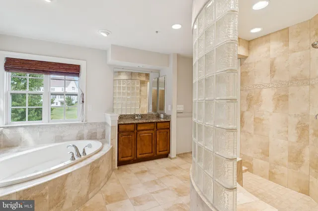 a spacious bathroom with a tub a sink and a shower
