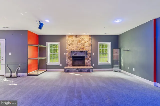 a view of an empty room with a fireplace and a window