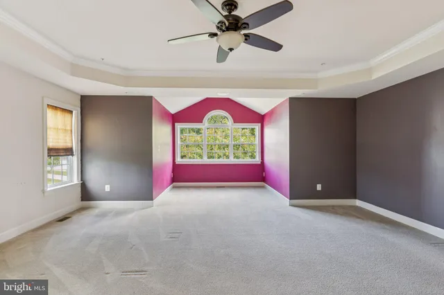 a view of an empty room with a window and fireplace