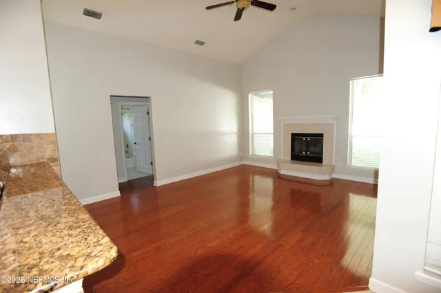 a view of empty room with wooden floor and fireplace