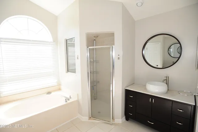 a bathroom with a tub sink and a mirror