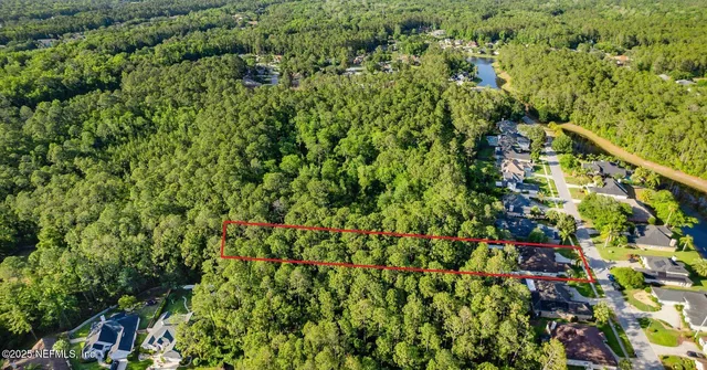 an aerial view of a house with a garden and large trees