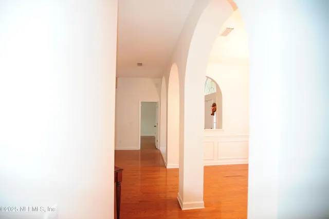 a view of a hallway with wooden floor