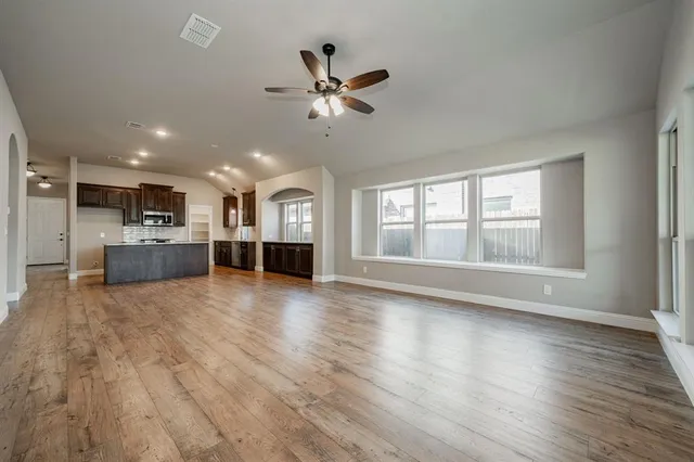 a view of a livingroom with furniture hardwood floor and a kitchen