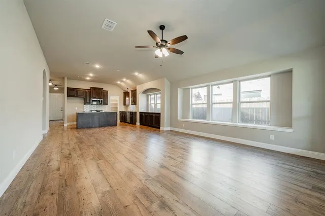 a view of empty room with wooden floor and window