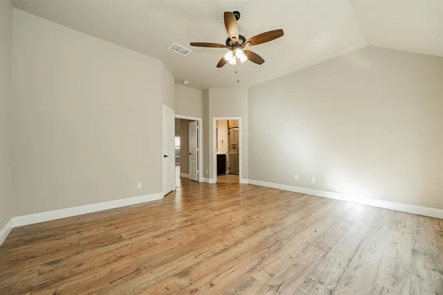 a view of an empty room with wooden floor