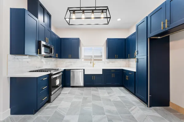 a kitchen with stainless steel appliances granite countertop a sink stove and microwave