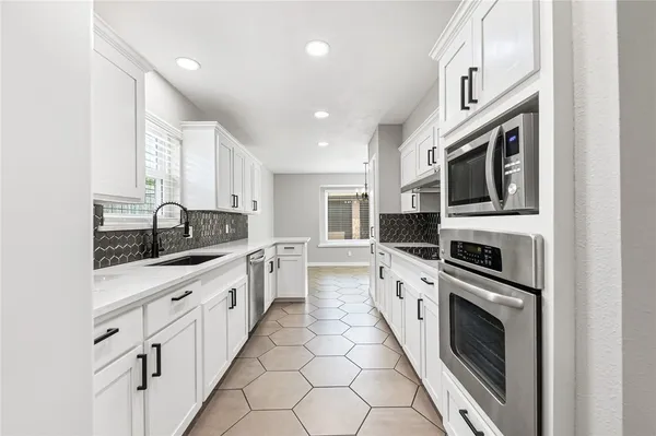 a large kitchen with stainless steel appliances granite countertop a lot of counter space and a sink