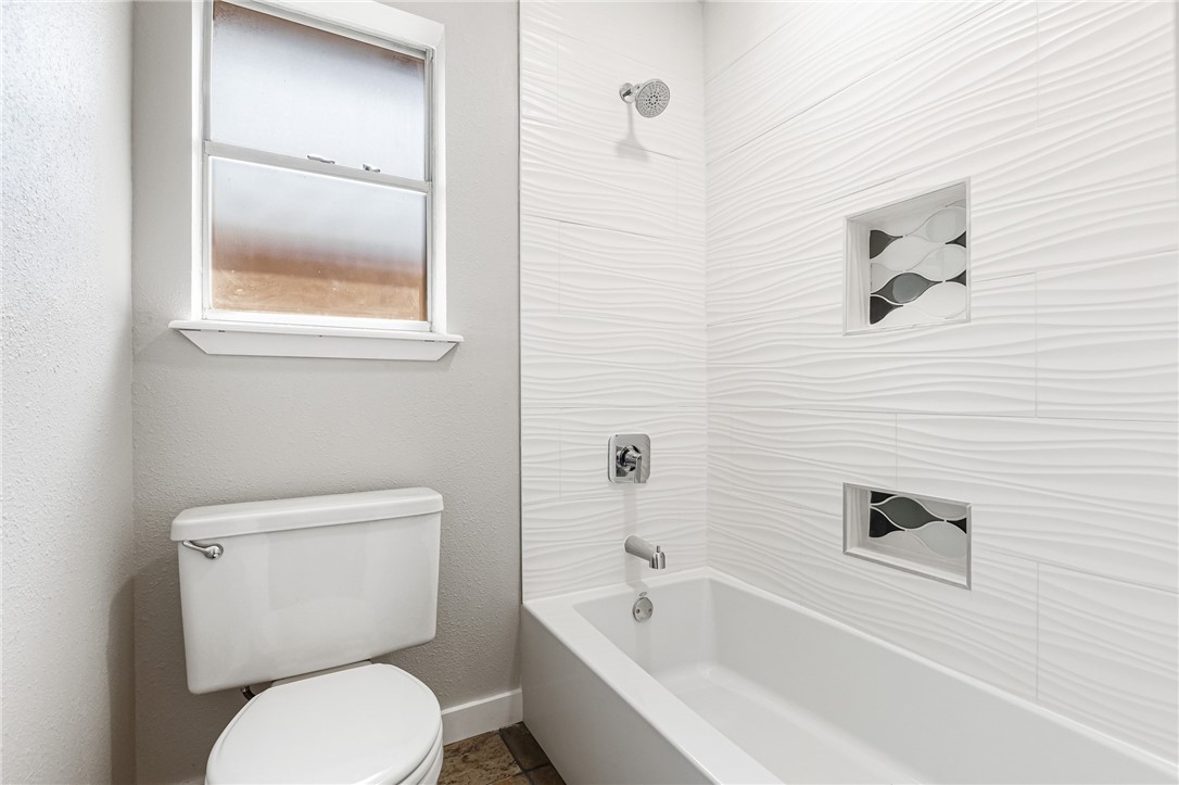 5038 Crestwick Drive Corpus Christi, TX 78413 - Photo 10 of 28 a white toilet sitting next to a bath tub