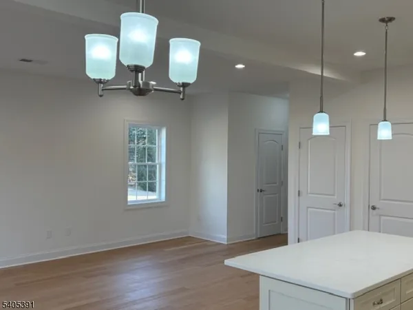 a view of a hallway with entryway a chandelier and wooden floor