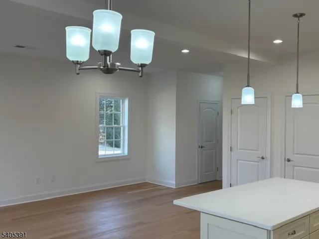 a view of a hallway with entryway a chandelier and wooden floor