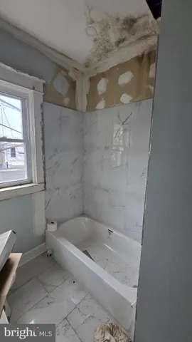 a white bath tub sitting next to a toilet