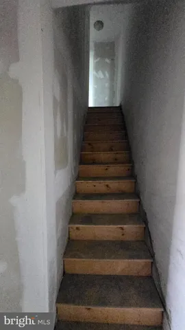 a view of a livingroom with wooden floor and staircase