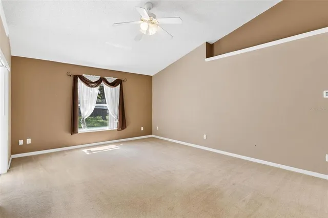 an empty room with fan and entrance