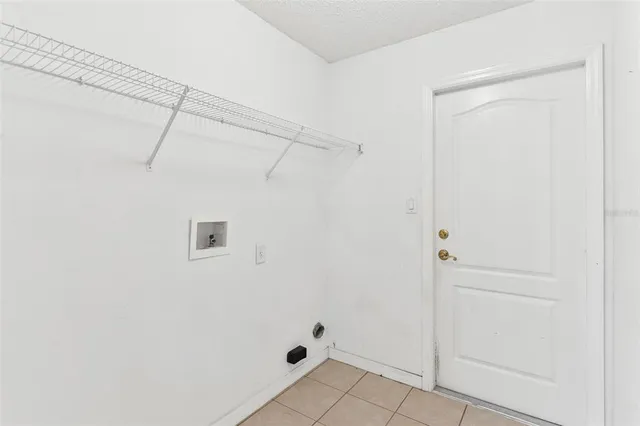 a view of an empty room with window and a fan