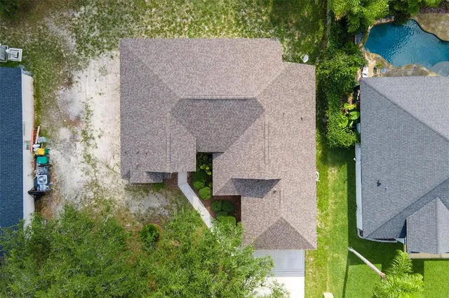 a aerial view of a house with a yard and a large tree