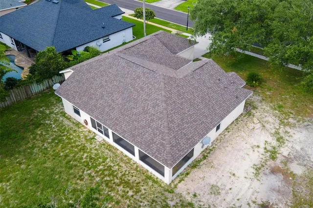 an aerial view of a house with a yard and tennis court