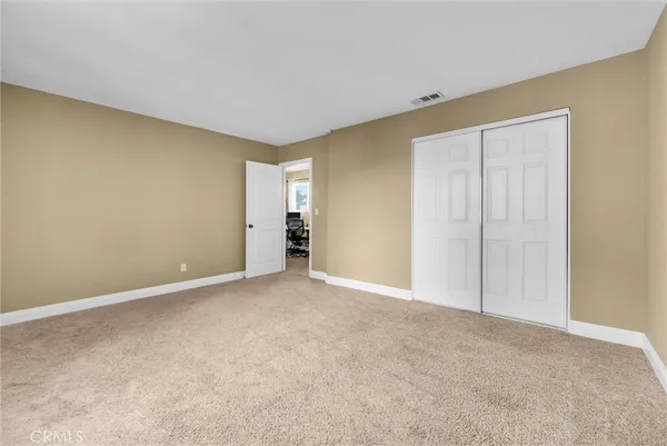 a view of an empty room and chandelier fan