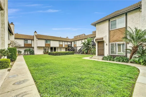 a front view of a house with a yard and potted plants