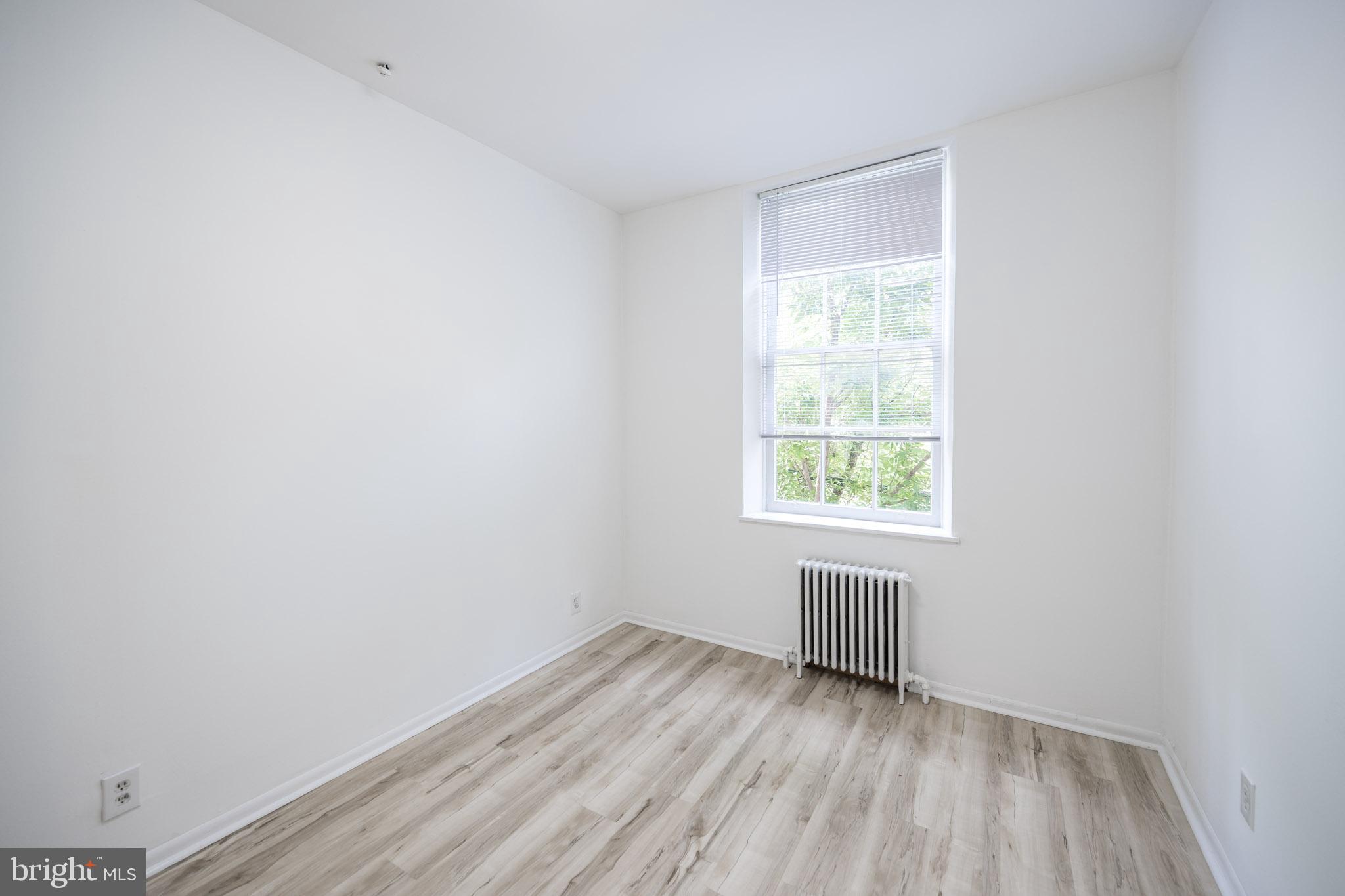 625 South 10th Street, Unit 2F Philadelphia, PA 19147 - Photo 7 of 13 a view of an empty room with wooden floor and a window