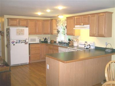 274 Simon Narrows Road Mashpee, MA 02649 - Photo 8 of 28 a kitchen with stainless steel appliances granite countertop a sink a stove and a refrigerator with wooden floor