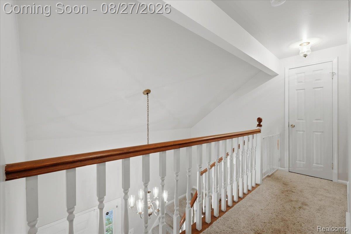 10100 Springtime Circle Clarkston, MI 48348 - Photo 39 of 73 White paneled door, wood-finish handrail, white balusters, and neutral carpeting