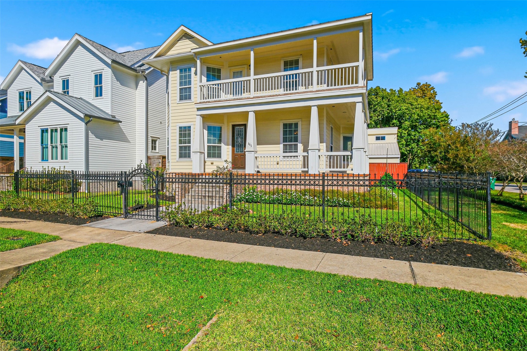 a front view of a house with a yard and potted plants