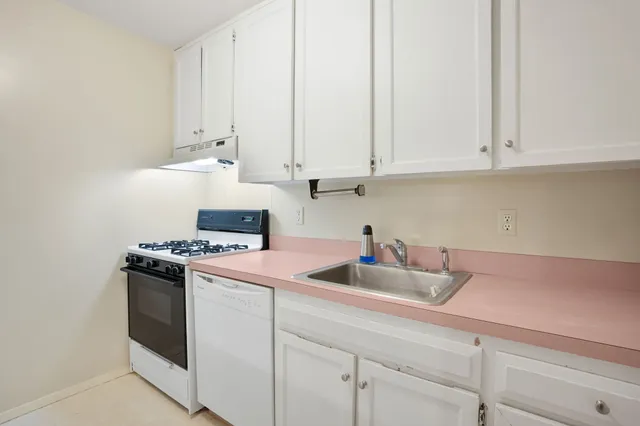a kitchen with white cabinets and white appliances
