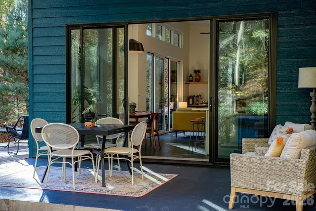 a view of a patio with table and chairs and couches with wooden floor