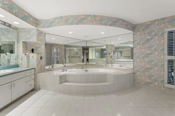 a large white bathroom with a sink and mirror