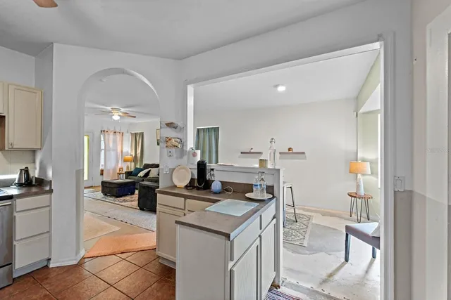 a living room with furniture a rug kitchen view and a fireplace