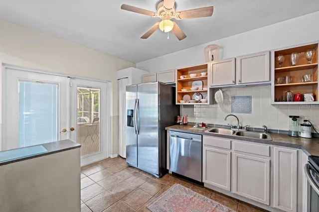 a kitchen with stainless steel appliances a sink a refrigerator and cabinets