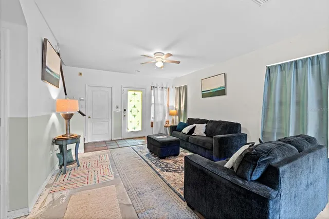 a living room with furniture a chandelier and a window