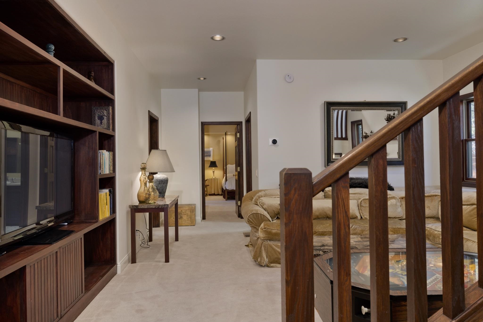 378 Ridge Way Mammoth Lakes, CA 93546 - Photo 5 of 43 Built-in wood shelving unit with lower cabinetry, recessed lighting, and a wood-finish staircase
