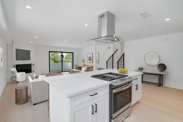 a kitchen that has a stove and a wooden floor