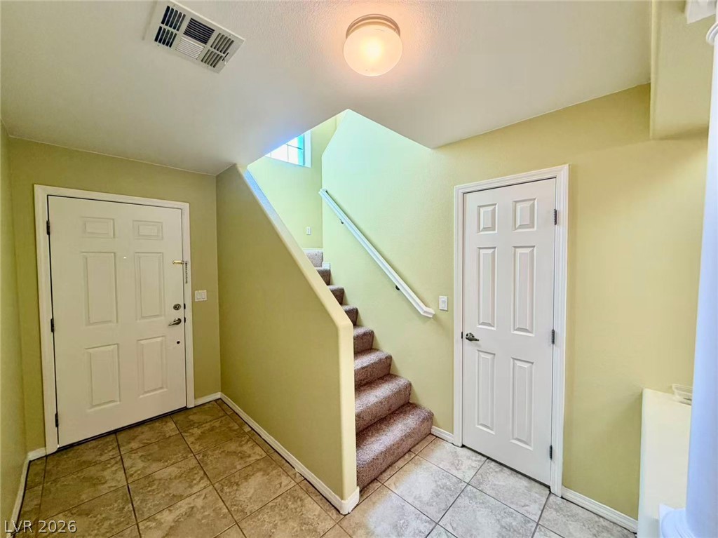 7326 Dicentra Road Las Vegas, NV 89113 - Photo 6 of 18 Durable tile flooring spans the welcoming entry hall leading up to carpeted stairs.