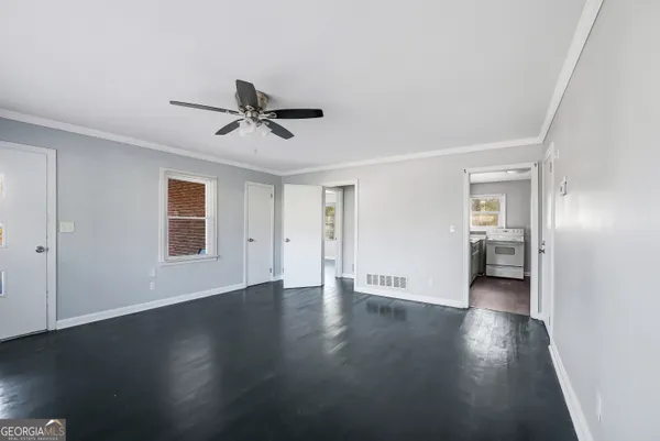 a view of a livingroom with wooden floor and a ceiling fan