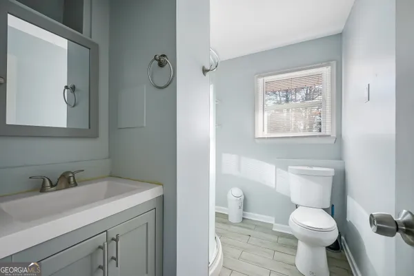 a bathroom with a toilet sink and mirror