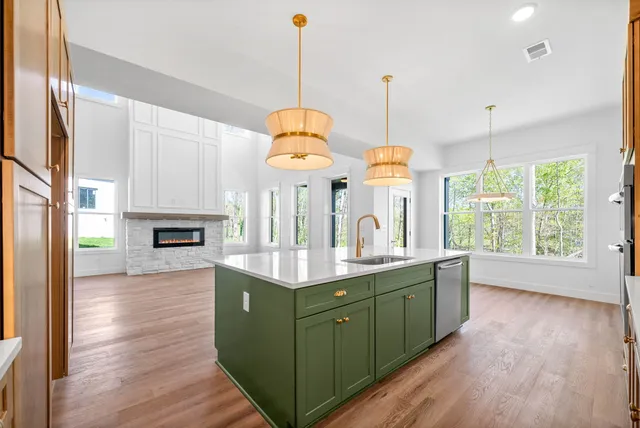 a kitchen with kitchen island granite countertop a sink cabinets and wooden floor