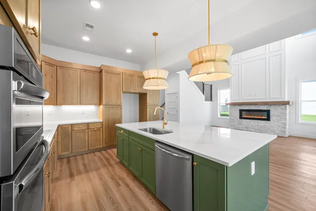 a kitchen with kitchen island granite countertop a stove and a sink